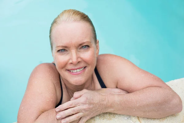 Mulher madura apoiando-se na piscina — Fotografia de Stock