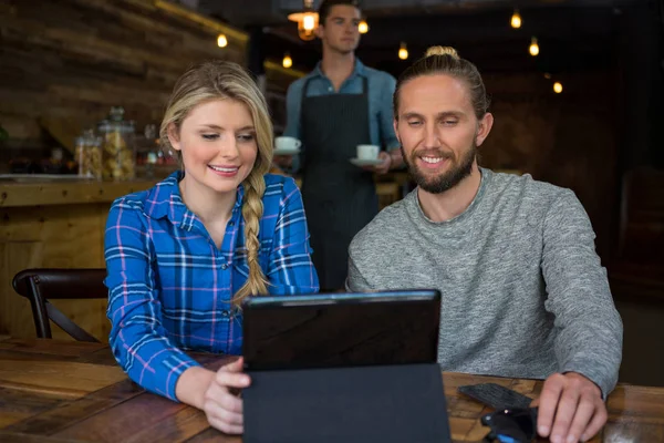 Ehepaar nutzt Tablet-Computer am Tisch — Stockfoto