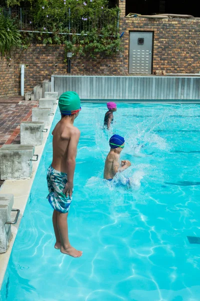 Nadadores saltando en la piscina en el centro de ocio —  Fotos de Stock