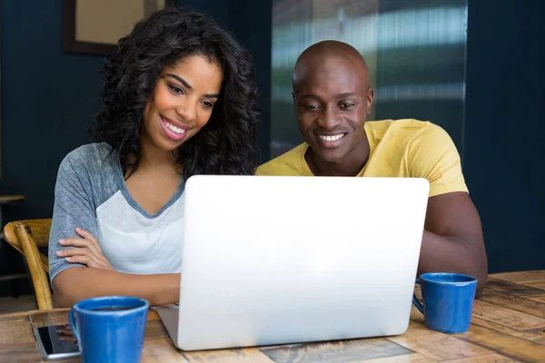 Casal usando laptop à mesa no café — Fotografia de Stock