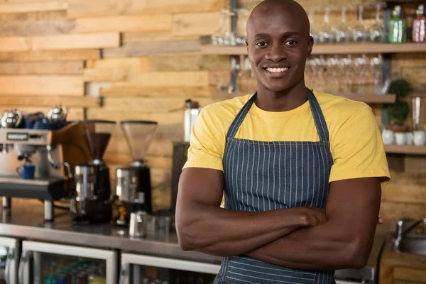 Male barista standing arms crossed