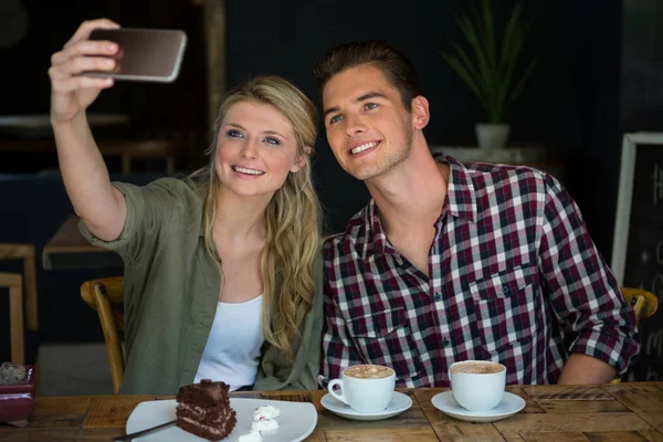 Couple prenant selfie avec téléphone portable à la cafétéria — Photo
