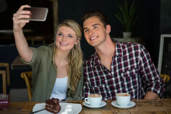 Casal tomando selfie com celular na cafetaria — Fotografia de Stock