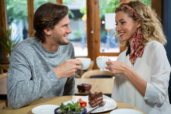 Пара пьет кофе за столом в кафетерии — стоковое фото
