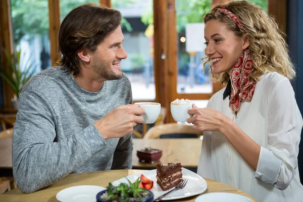 Casal tomando café à mesa na cafetaria — Fotografia de Stock