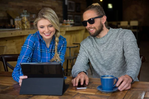 Para przy użyciu komputera typu tablet przy stoliku w kawiarni — Zdjęcie stockowe