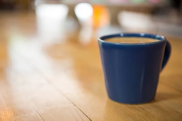 Taza de café sobre mesa de madera en cafetería —  Fotos de Stock