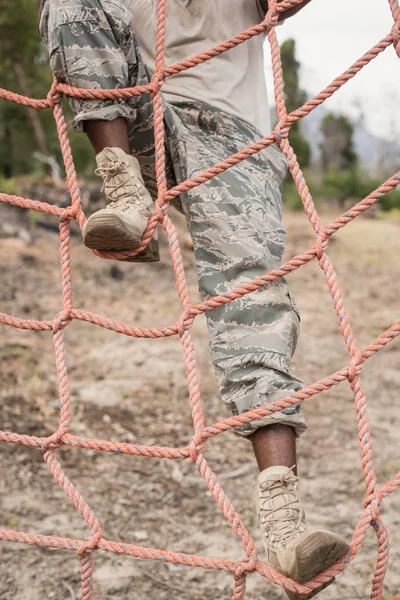 Soldado militar escalando uma rede — Fotografia de Stock