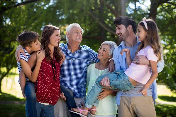 Sorrindo família posando juntos no parque — Fotografia de Stock