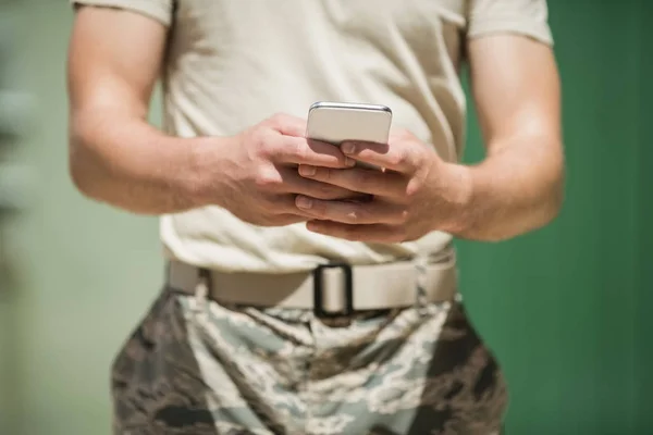 Militær soldat som bruker mobiltelefon – stockfoto