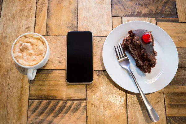 Teléfono inteligente con pastelería y taza de café — Foto de Stock