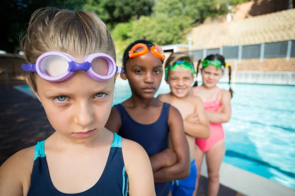 Fila de amigos de pie junto a la piscina —  Fotos de Stock