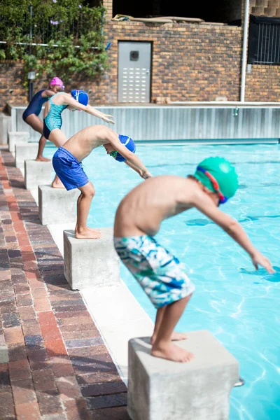 Yüzme havuzunda atlamak için pozisyon almak yüzücüler — Stok fotoğraf