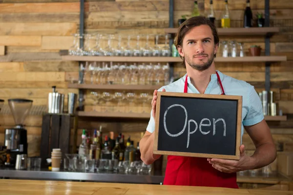 Barista hålla öppen skylt i kafé — Stockfoto