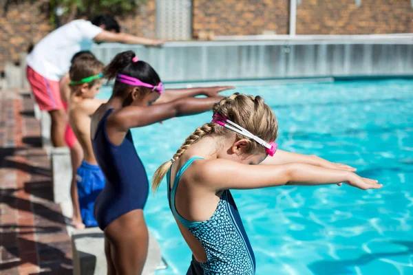 Nuotatori con allenatore pronti a saltare in piscina — Foto Stock