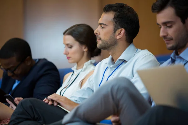 Dirigenti aziendali che partecipano a una riunione di lavoro utilizzando dispositivi elettronici — Foto Stock