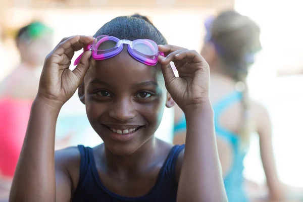 Smiling girl holding swimming goggles — Stock Photo, Image