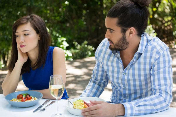 Ung man tittar upprörd kvinna på restaurang — Stockfoto