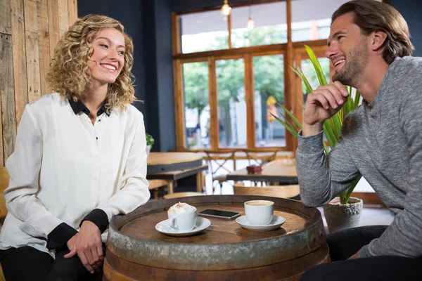 Улыбающаяся пара разговаривает в кафе — стоковое фото