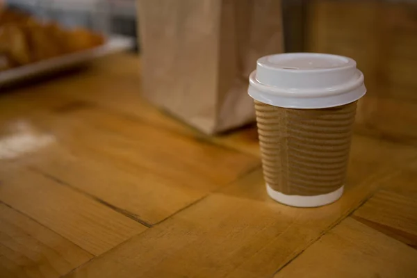 Одноразова чашка кави на столі в кафе — стокове фото