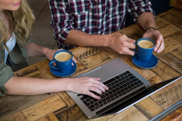 Ζευγάρι χρησιμοποιώντας φορητό υπολογιστή ενώ έχοντας καφέ — Φωτογραφία Αρχείου