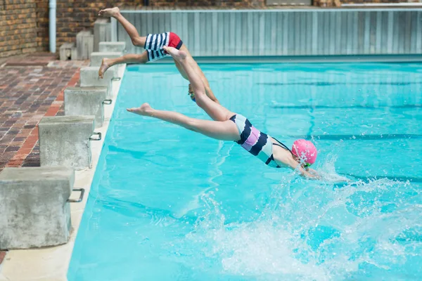 Bambini che si tuffano in acqua a bordo piscina — Foto Stock