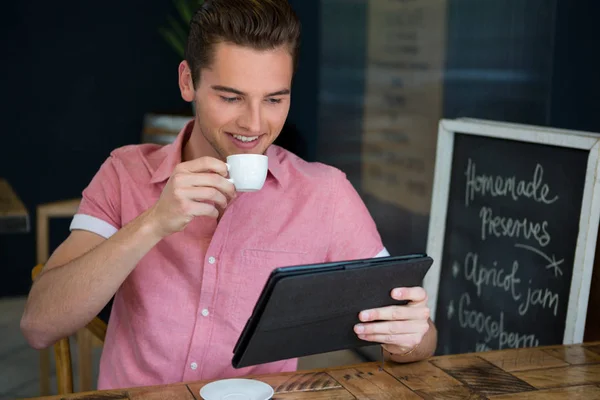 Man having coffee while using tablet — Stock Photo, Image