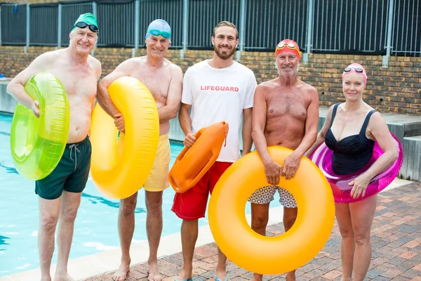 Salvavidas masculino con nadadores senior de pie junto a la piscina —  Fotos de Stock