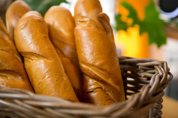 Fresh baked bread loaves in wicker basket — Stock Photo, Image