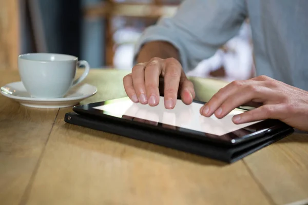 Man using tablet at table in coffee shop — Stock Photo, Image