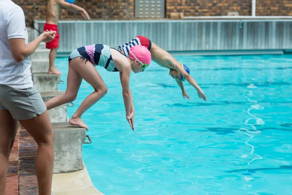 Instrutora do sexo feminino tempo de monitoramento de crianças mergulho — Fotografia de Stock