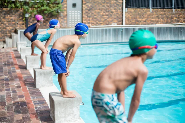 Nadadores esperando em afirmar blocos na beira da piscina — Fotografia de Stock