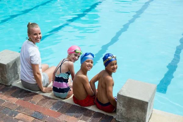 Veselém plavání instruktor a studenty na bazénu — Stock fotografie