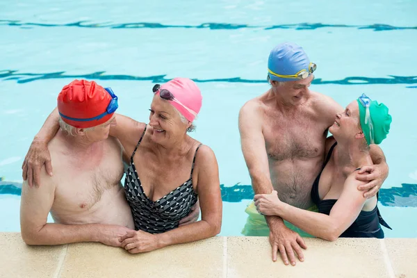 Parejas mayores felices disfrutando en la piscina — Foto de Stock