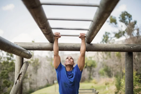 Fitter Mann klettert auf Affenstangen — Stockfoto