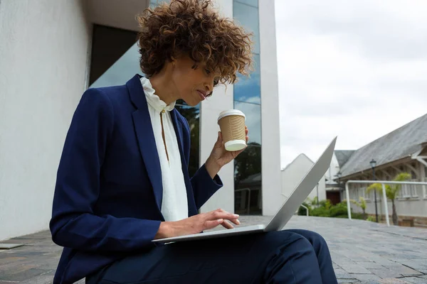 Affärskvinna med laptop med kopp kaffe — Stockfoto