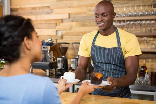 Male barista serving coffee and dessert to female — Stock Photo, Image