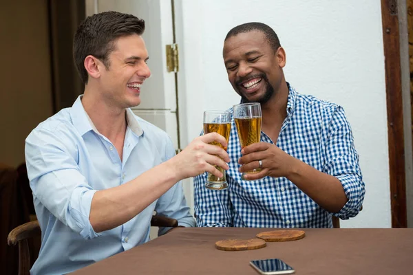 Uomini brindare bicchieri di birra al tavolo del ristorante — Foto Stock