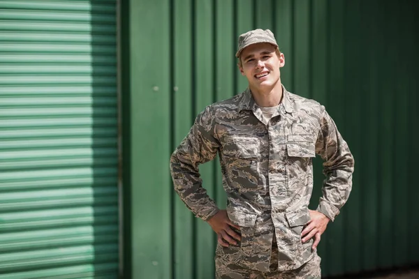 Soldado militar sorridente de pé com as mãos na anca — Fotografia de Stock