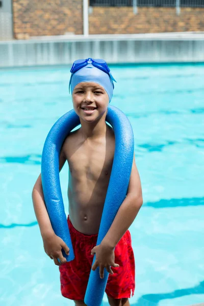 Boy with pool noodle smiling at camera — Stock Photo, Image