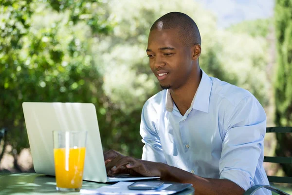 Businessman using laptop at restaurant — Stock Photo, Image