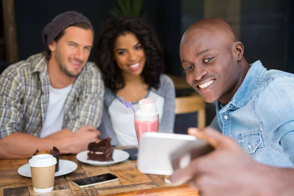 Amici che prendono selfie a tavola di legno — Foto Stock