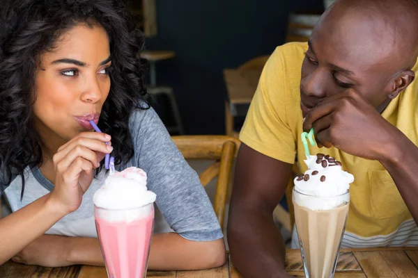 Verliefde paar gelet milkshakes aan tafel — Stockfoto