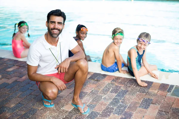 Instructeur masculin et étudiants au bord de la piscine — Photo