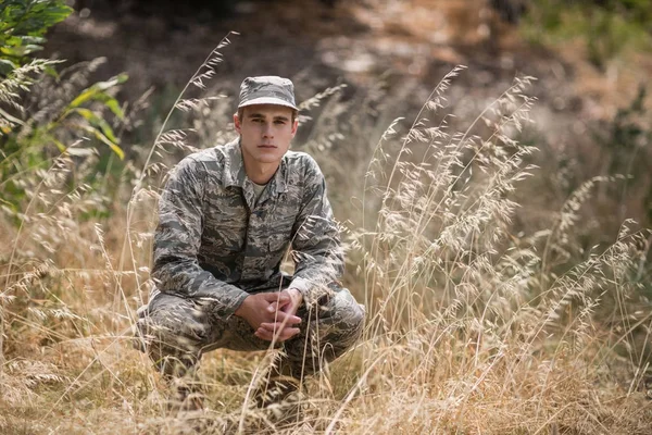 Soldat militaire accroupi dans l'herbe — Photo