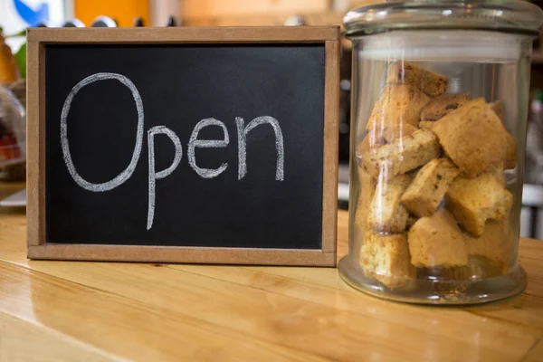 Ouvrir signe par des cookies dans un bocal sur le comptoir — Photo