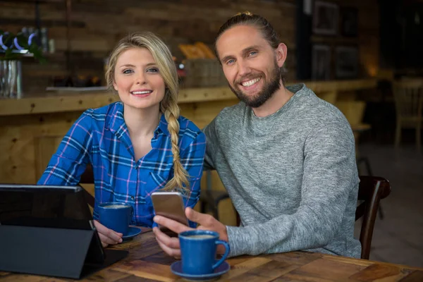 Casal com café e tecnologias no café — Fotografia de Stock