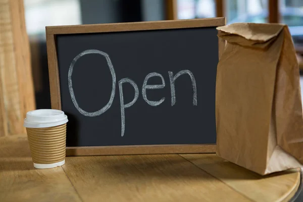 Panneau ouvert avec tasse à café jetable — Photo