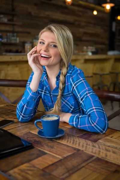 Kobieta siedząca przy stoliku w kawiarni — Zdjęcie stockowe