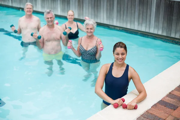 Allenatrice con nuotatori anziani in piscina — Foto Stock